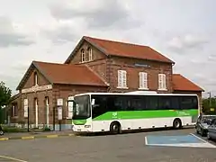 Le bâtiment voyageurs avec un car des TER Picardie stationné devant.