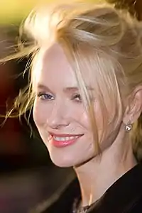Photographie du visage souriant d’une jeune femme blonde.
