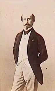 Portrait photographique d'un homme se tenant debout.