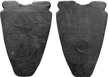 Face de la palette de Narmer, utilisant une forme archaïque du hiéroglyphe Harpon (photo de gauche).