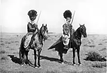 Photo en noir et blanc de deux cavaliers avec coiffes.