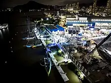 Vue aérienne du port, de nuit. Quatre Imoca sont amarrés dans le bassin, tandis que Biotherm est au sec.