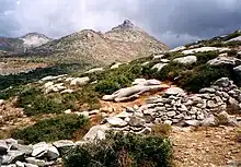 photographie : paysage de pierres : une statue inachevée est couchée sur le dos