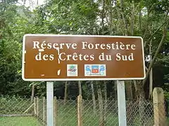 Armoiries sur un panneau d'indication dans la forêt de Chirongui (avec le logo de la DRAF).