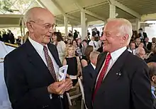 Photographie couleur de Collins et Aldrin se parlant lors d'une cérémonie.