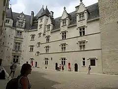 Photographie en couleur d'un château et de visiteurs.