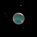 Neptune, entourée de points blancs, a une couleur plus sombre et des structures nuageuses roses sont visibles.