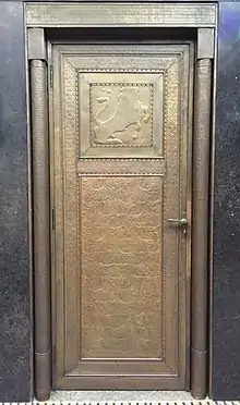 L'une des portes en métal repoussé