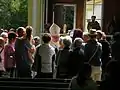 Un prêtre s'adressant aux gens après la messe.