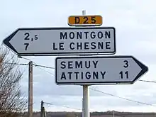 Deux panneaux de signalisation de direction surmonté d'un cartouche D25