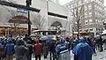 Une foule assistant au passage des bus des joueurs sous une fine neige.