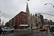 Le bâtiment rouge (au premier plan), au croisement de la Seconde Avenue et de la 7e rue, d'où l'incendie est parti avant de se propager à l'église.