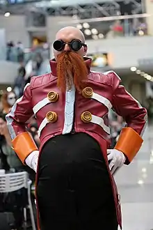 Cosplayeur déguisé en homme moustachu aux habits rouges.