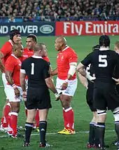 Des joueurs de rugby debout discutent pendant un arrêt de jeu.