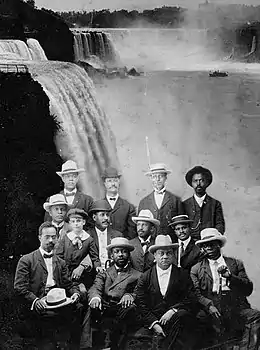 Une douzaine d'afro-américains sont assis avec les chutes du Niagara en arrière-plan