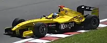 Photographie d'une Formule 1 jaune, vue de trois-quarts, près d'un vibreur.