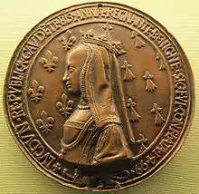 Photographie d'une médaille bronze représentant le profil gauche d'une reine sur fond d’hermines.