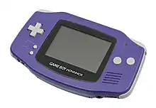 Console Game Boy Advance, sorte de boîtier de couleur violette avec un écran gris (éteint) et des boutons gris.
