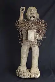 Sculpture en bois anthropomorphe, parsemée de clous