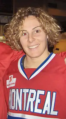 Photographie d'ne femme portant un maillot rouge, bleu et blanc de hockey sur glace.