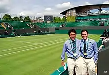 Deux arbitres posant devant le Court numéro trois