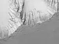 Noctis Lanyrinthus vu par Viking 1 Orbiter, montrant les nappes de brouillard matinal remplissant les vallées à proximité du cratère Oudemans, visible à gauche.