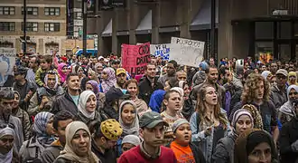 Image présentant plusieurs personnes défilant dans une rue de Montréal, certaines avec des pancartes