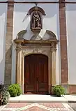 Portail principal néo-classique avec statue de saint Michel.