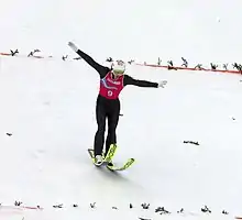 Un sauteur à ski à la réception de son saut.