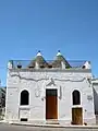 Trullo à la façade rehaussée cachant les deux cônes de toiture (Alberobello)