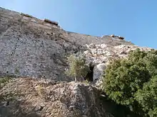 Pan de colline dominé par une muraille