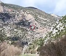 Situation de Notre-Dame-de-Vie. Vue vers le nord depuis les gorges de Fuilla dans la vallée de la Rotja. Au-dessus de la chapelle : la grotte naturelle, la "Cova de Sainte-Madeleine".