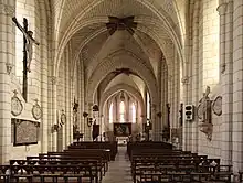 Photographie en couleurs d'une église dont le clocher est revêtu d'ardoises.