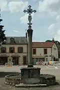 Une croix, sur la place du village.