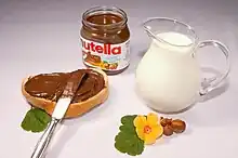 photo promotionnelle présentant un pot de Nutella disposé sur une table avec du pain et du lait.