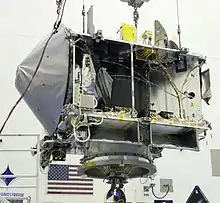 Photo de la sonde spatiale en partie assemblée en position suspendue.