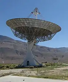 Photographie d'une antenne parabolique métallique pointant vers le ciel.