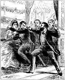 Dans une loge de théâtre, un homme barbu armé d'un couteau dans sa main gauche pointe de sa main droite un pistolet sur la tête du président Lincoln, qui se recule dans les bras de sa femme.