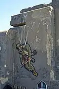 Peinture d'un parachutiste sur un mur de béton.