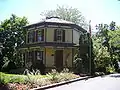 Maison à ossature bois de taille modeste mais décorative, vue ici peinte dans des couleurs de "patrimoine" qui peuvent refléter la palette de couleurs d'origine.  Octagon House, Barrington, Illinois (construite en 1860).