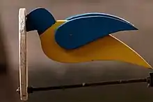 Photo en gros plan d'un objet en forme d'oiseau de couleur bleu et jaune.