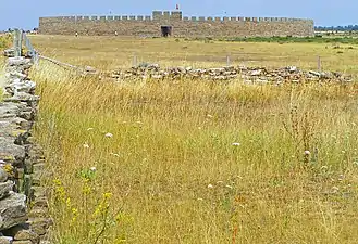 Paysage agricole du sud d'Öland, où était pratiqué le solskifte, avec la forteresse d'Eketorp en arrière-plan.