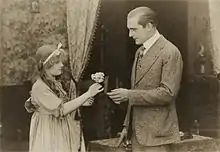 Katie Ruder (Dorothy Gish) offre un bouquet de fleurs au Prince Karl Heinrich (Wallace Reid).