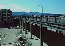 A car and two bicyclists going across a viaduct