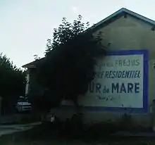 Publicité peinte sur le mur d'une ferme: "2 km apres Fréjus, le centre residentiel de la Tour de Mare vous attend..."