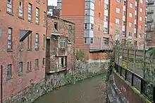 Photographie de façades lépreuses au-dessus d'un canal.