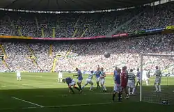 plusieurs footballeurs se disputent le ballon près d'un but
