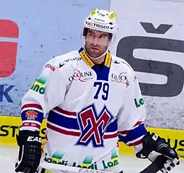 Photographie couleur d’un hockeyeur de dos aux trois quarts et se penchant en avant