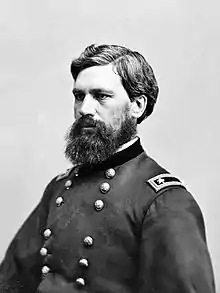 Portrait noir et blanc d'un homme en tenue militaire portant la barbe.