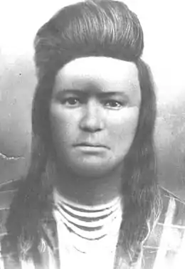 Portait noir et blanc d'un jeune Amérindien avec les cheveux au-dessus du front enroulés vers l'arrière.